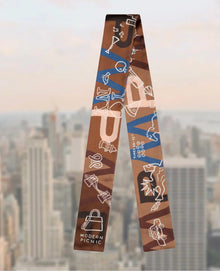 Brown and blue patterned fashion scarf with New York icons, Modern Picnic lunch bag logo, cityscape background