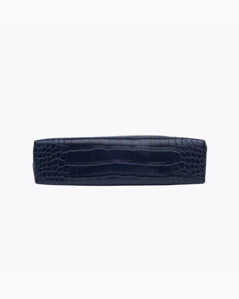 A view of the flat, rectangular base of the small navy blue pouch, showing the crocodile-embossed texture.