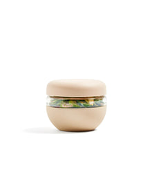 Oat-colored insulated food storage bowl with clear middle, filled with salad, on white background