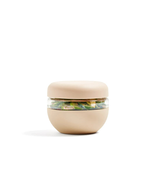 Oat-colored insulated food storage bowl with clear middle, filled with salad, on white background
