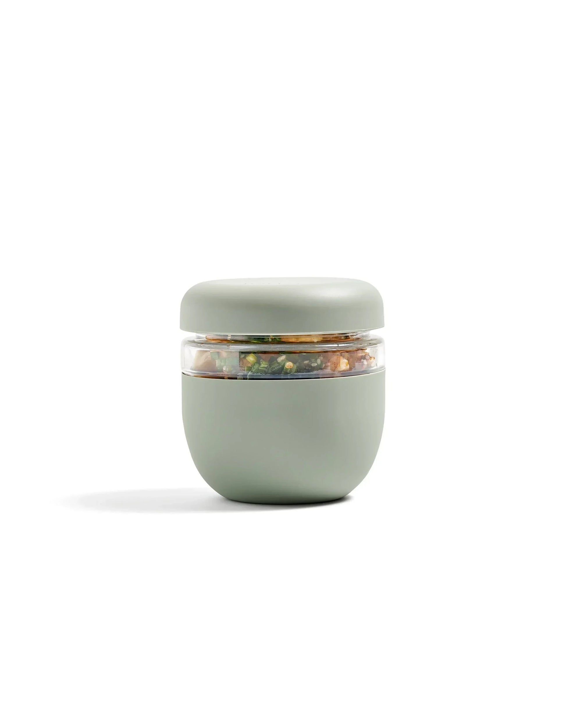 Sage green insulated lunch container with clear seal, filled with salad, modern design