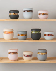 Assorted airtight food storage containers with snacks on wooden shelves