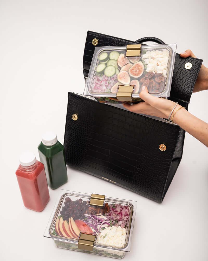 Overhead view of open large luncher with containers and drinks arranged inside