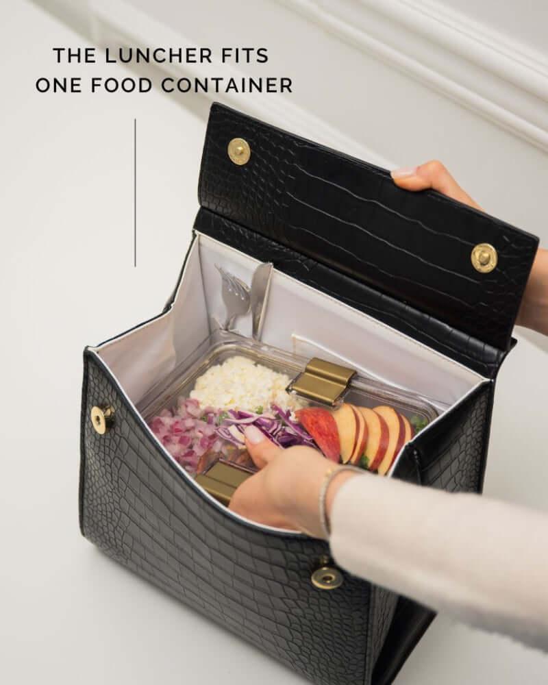 Open view of black luncher bag showing insulated interior with food container inside
