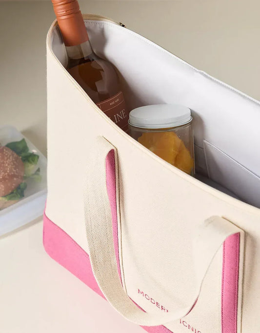 Chic insulated lunch tote bag with a wine bottle and jar, pink and beige design, on table