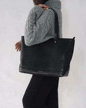 Modern Picnic black pebble tote bag worn over shoulder by woman in grey sweater and black pants