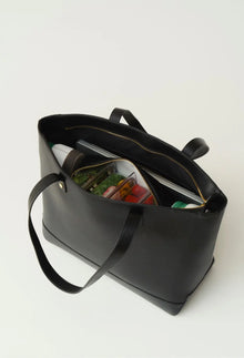 Modern Picnic black tote bag open on a white background, revealing food containers neatly organized inside.
