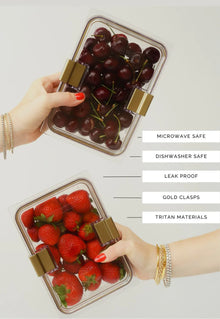 Person holding two Modern Picnic glass containers filled with strawberries and cherries.