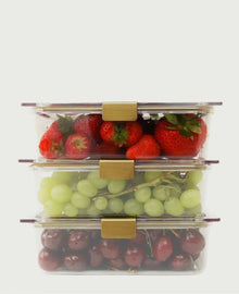 Three Modern Picnic glass food containers stacked with strawberries, grapes, and cherries.