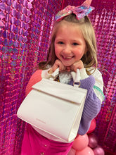 Smiling child holding the Modern Picnic mini cream croc bag from the Mommy and Me Set.