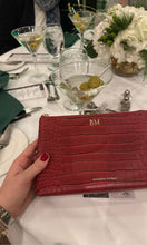 Close-up of Modern Picnic red clutch from THE DAY TO NIGHT SET on a dinner table, showing elegant evening styling.
