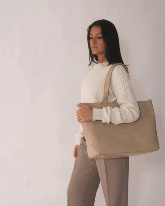 Model posing with Modern Picnic tote in cream croc vegan leather, styled with beige trousers and a white sweater.