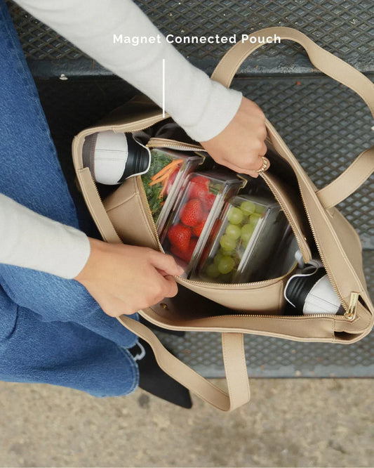 Beige insulated lunch tote with magnet pouch, holding fresh fruit containers and water bottle, ideal for work or travel.