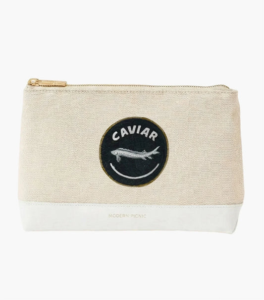 Beige canvas pouch with 'Caviar' fish patch, gold zipper, white vegan leather base — chic lunch accessory