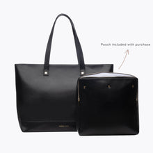 A studio shot showing a large black tote bag next to a matching black zippered pouch. The text "Pouch included with purchase" is visible, along with a gold zipper on the pouch and the logo on the tote.