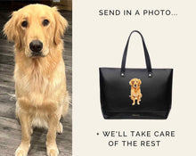 A side-by-side composite image showing a live Golden Retriever dog on the left and a black tote bag on the right featuring a custom hand-painted portrait of the same dog. Text reads: "SEND IN A PHOTO... + WE'LL TAKE CARE OF THE REST."