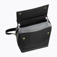 Open view of black pet portrait backpack showing interior space and gold snap details